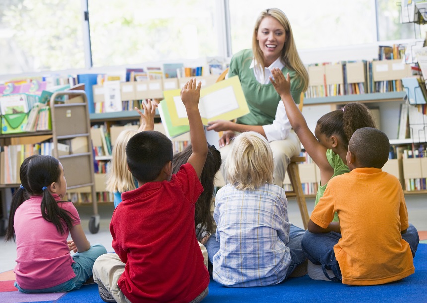 woman reading a book to children