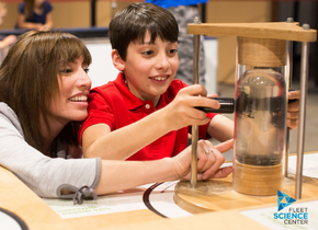 Woman and boy interacting with a science exhibit.