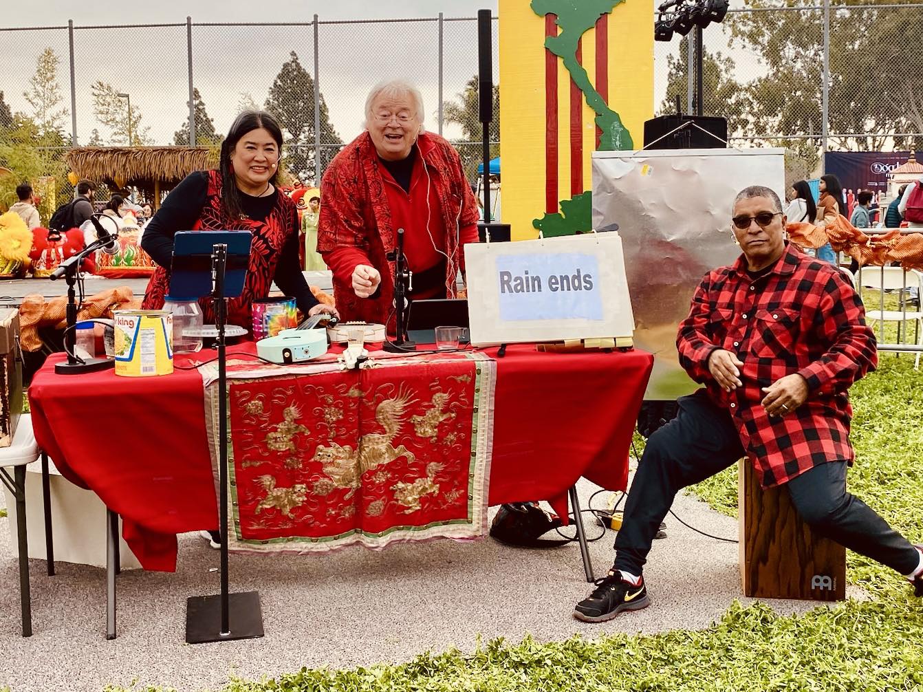 Photo of members of Asian theater troupe at an outreach table at an outdoor event