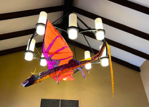 Picture of a dragon kite hanging from a chandelier at the La Jolla/Riford Library. 