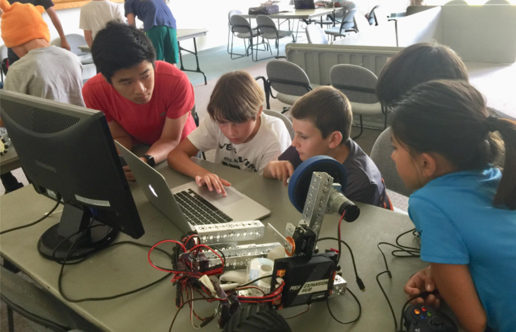 Children using a computer to program a robot
