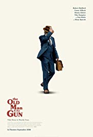 Film poster. Man walking and holding a briefcase. He is wearing a suit and hat.