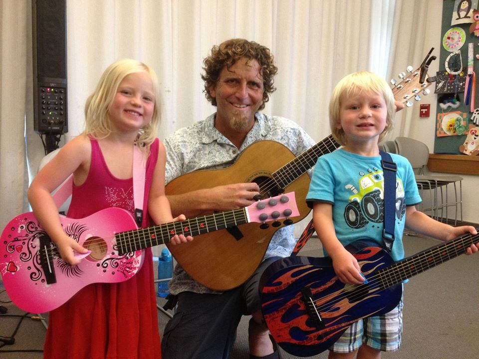 Man with guitar and two children