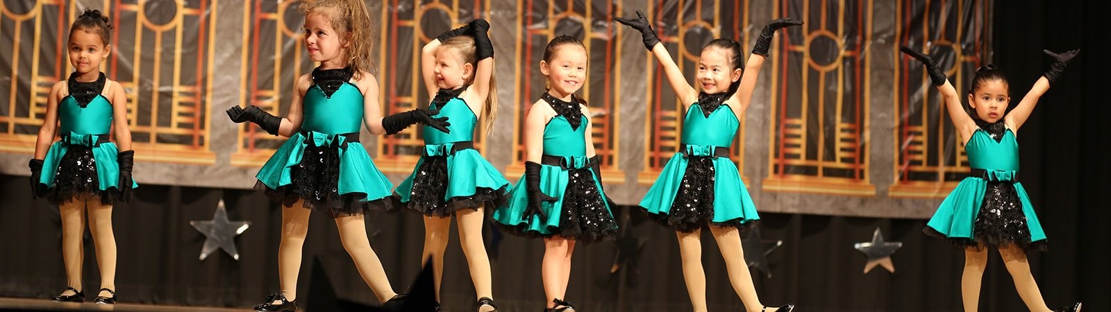 little girls on stage in their dance costumes