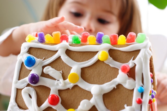 Child decorating a gingerbread house