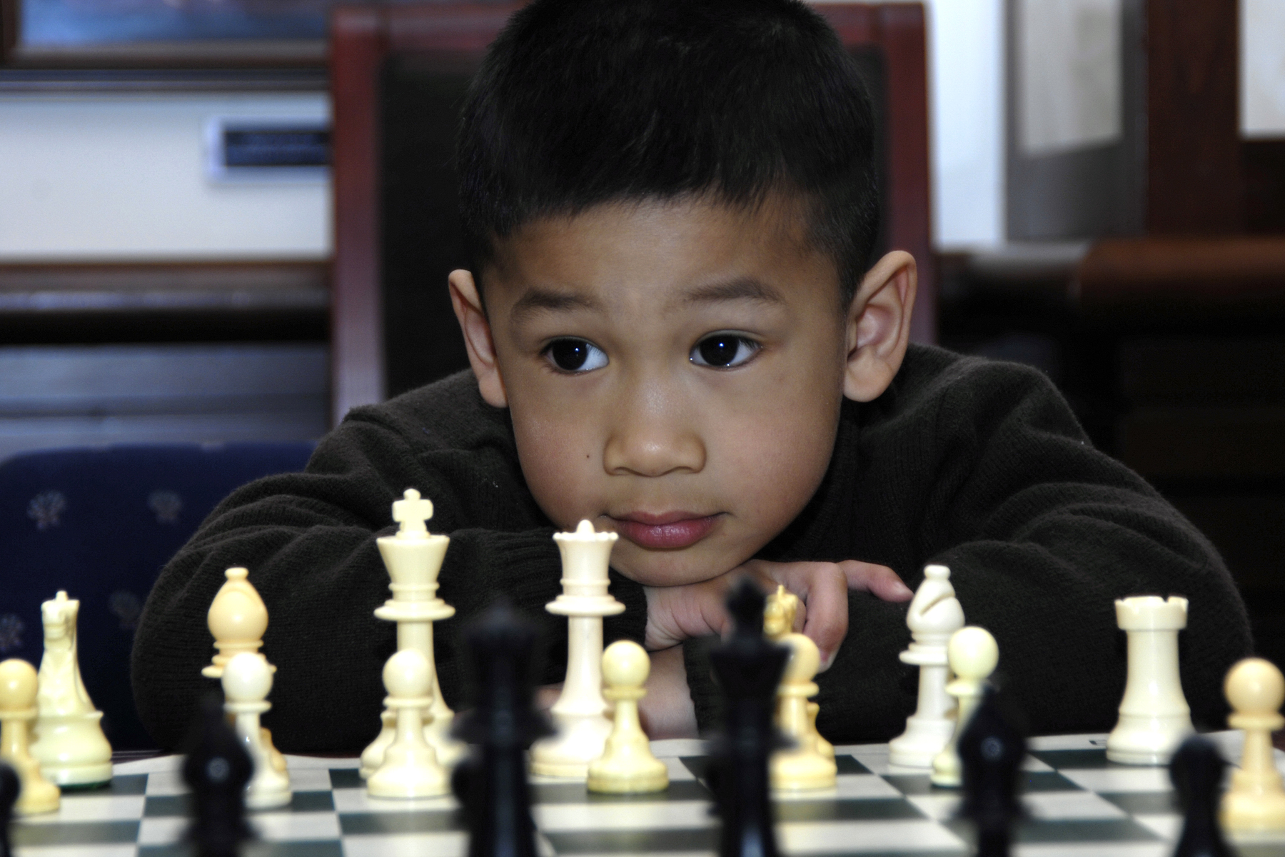 boy staring at a chess board