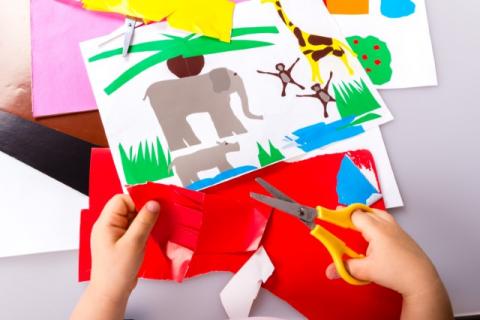 Child cutting paper for craft