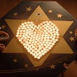 A star with lighted candles forming a heart within it.