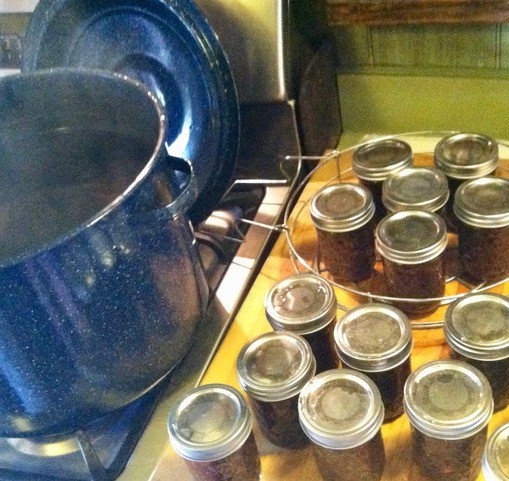 Jars of preserves next to a pot of water