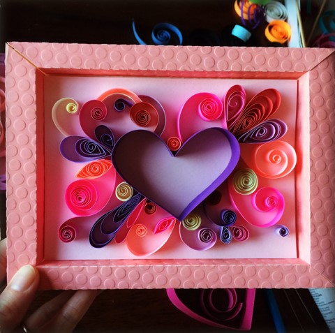 Paper heart with paper embellishments in a pink picture frame