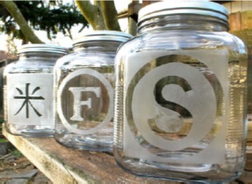Three large glass jars decorated in letters and symbols. 