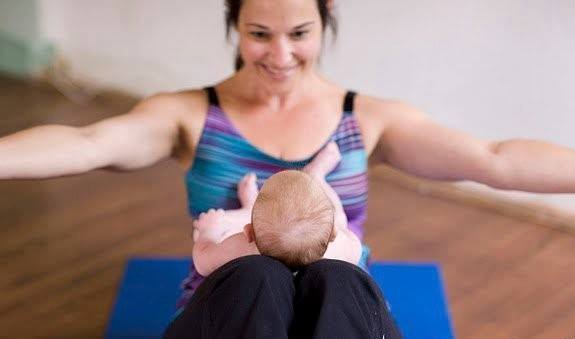 Woman performing yoga with a baby