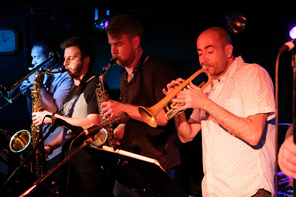 Musicians playing saxophones and trumpets