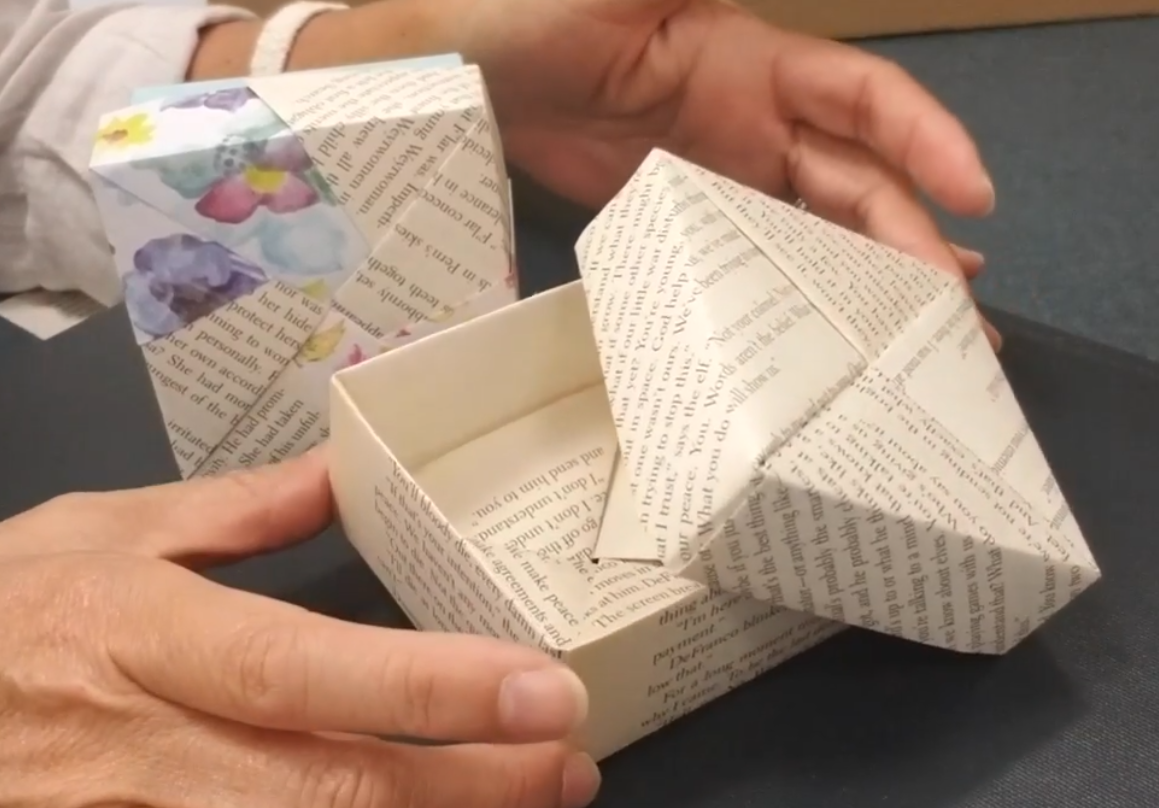 hands opening an origami gift box