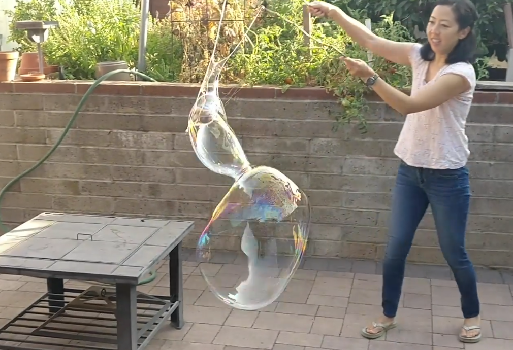 Librarian making a large bubble with bubble wand