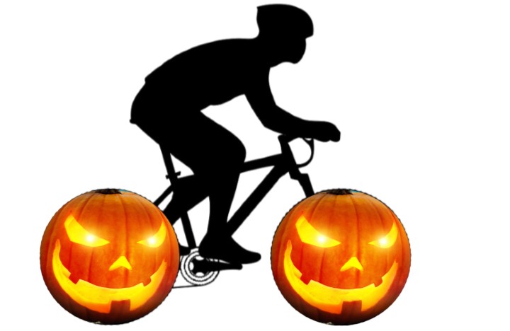 Silhouette of a bicyclist, where the bike's wheels look like jack-o-lanterns