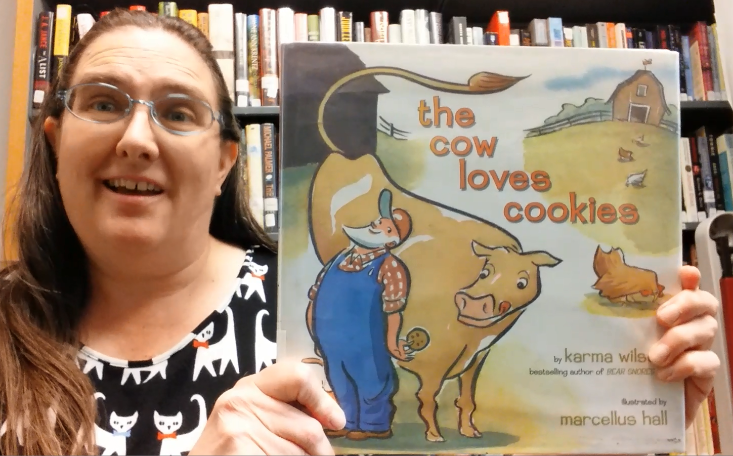 librarian holding up book "The Cow Loves Cookies"