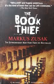 Cover of The Book Thief by Markus Zusak. A finger is touching a domino set to fall in sequence.