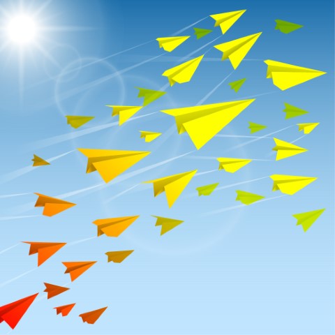 Red, orange, and yellow paper airplanes flying across a blue, sunny sky