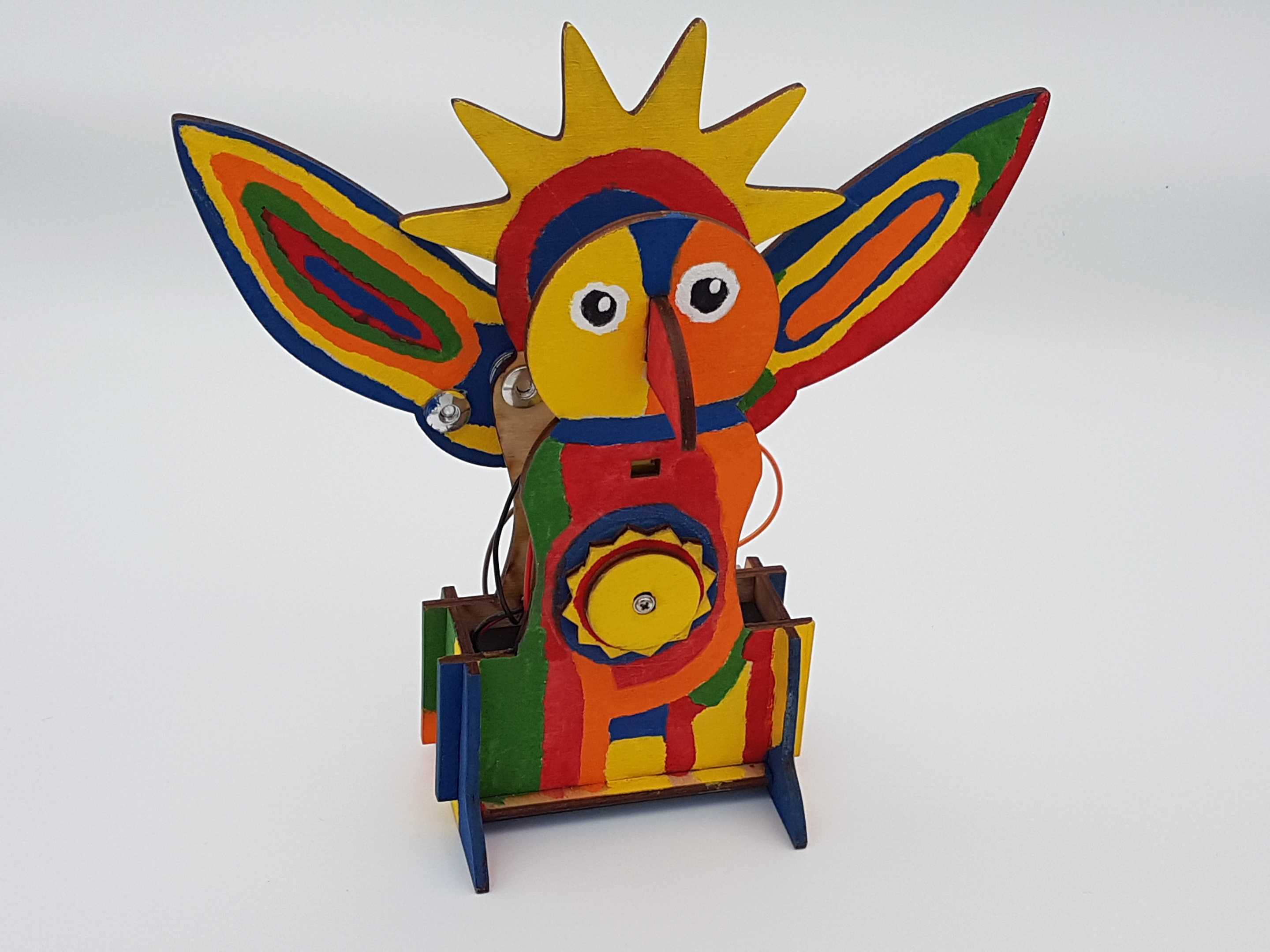 Colorfully painted small wooden robot resembling a Sun God