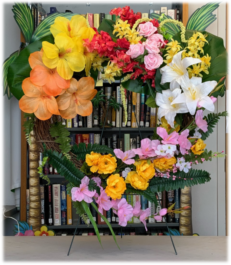 Image of a tropical floral wreath in the shape of a heart with many bright & colorful flowers.