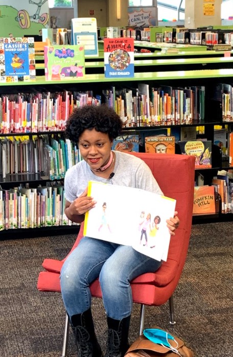 Story teller holds up book at the Central Library