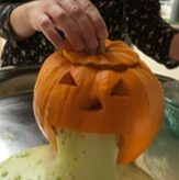 Carved pumpkin with green foam oozing out of the mouth