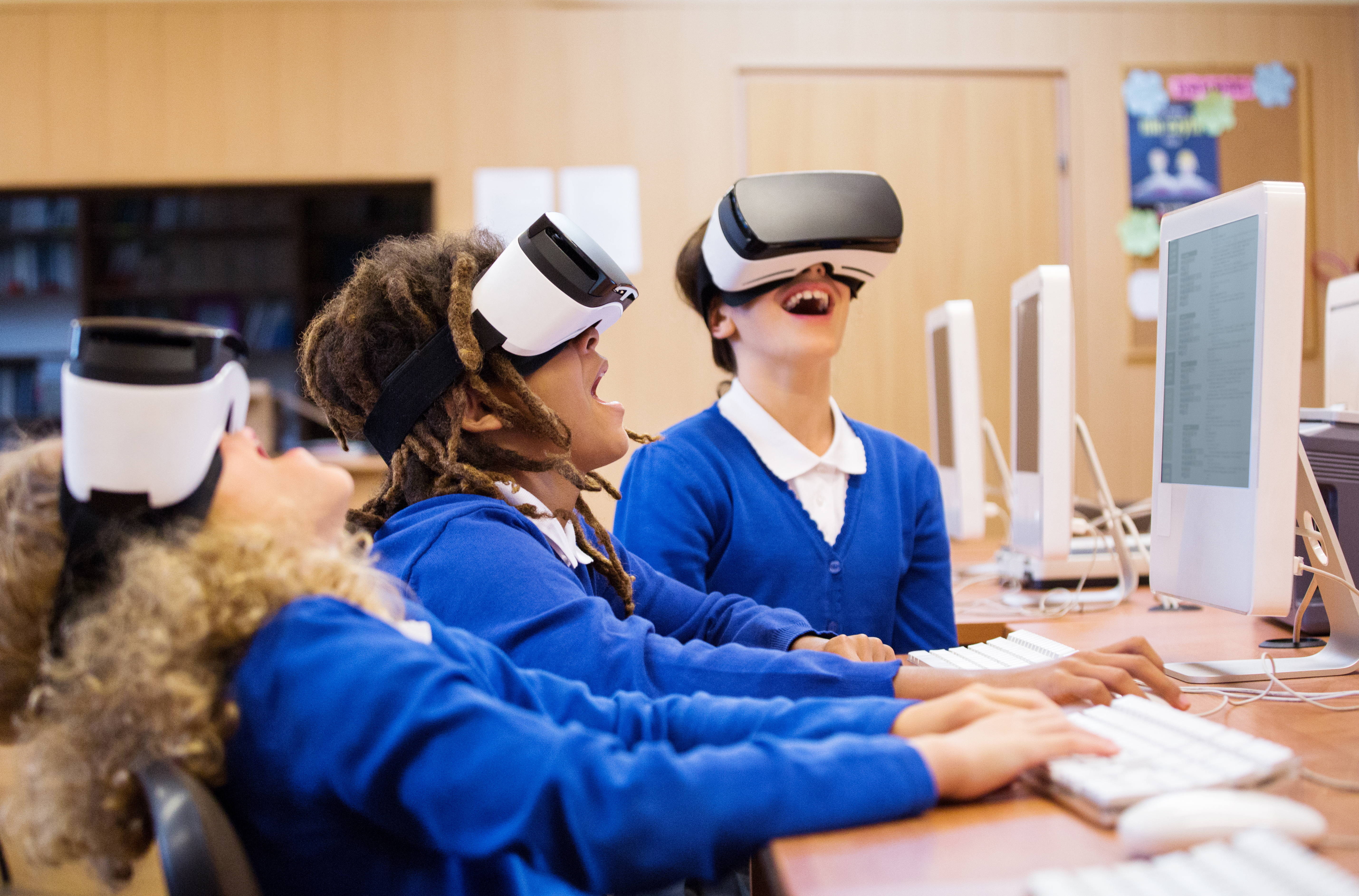 Students with virtual reality headsets at a computer.