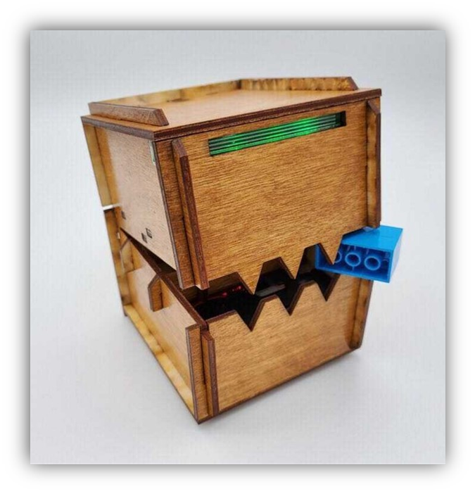 Wooden box with teeth eating blue LEGO.