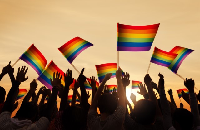 Raised hands holding Pride flags