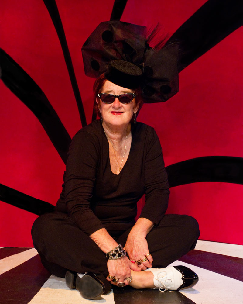Sue Palmer sitting in front of a red and black background