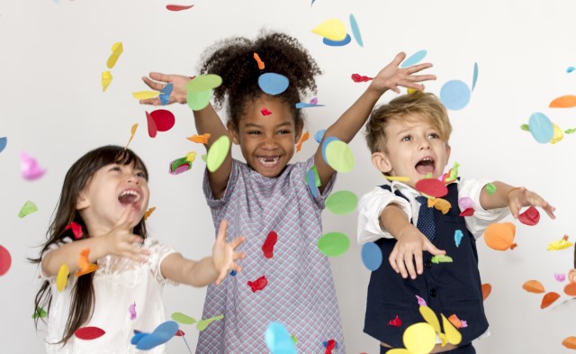 three children surrounded by falling confetti
