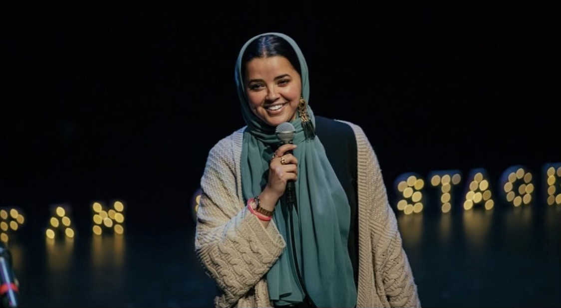 Photo of comedian Aziza Gaouda holding a microphone