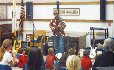 Musician performing in front of a group of children