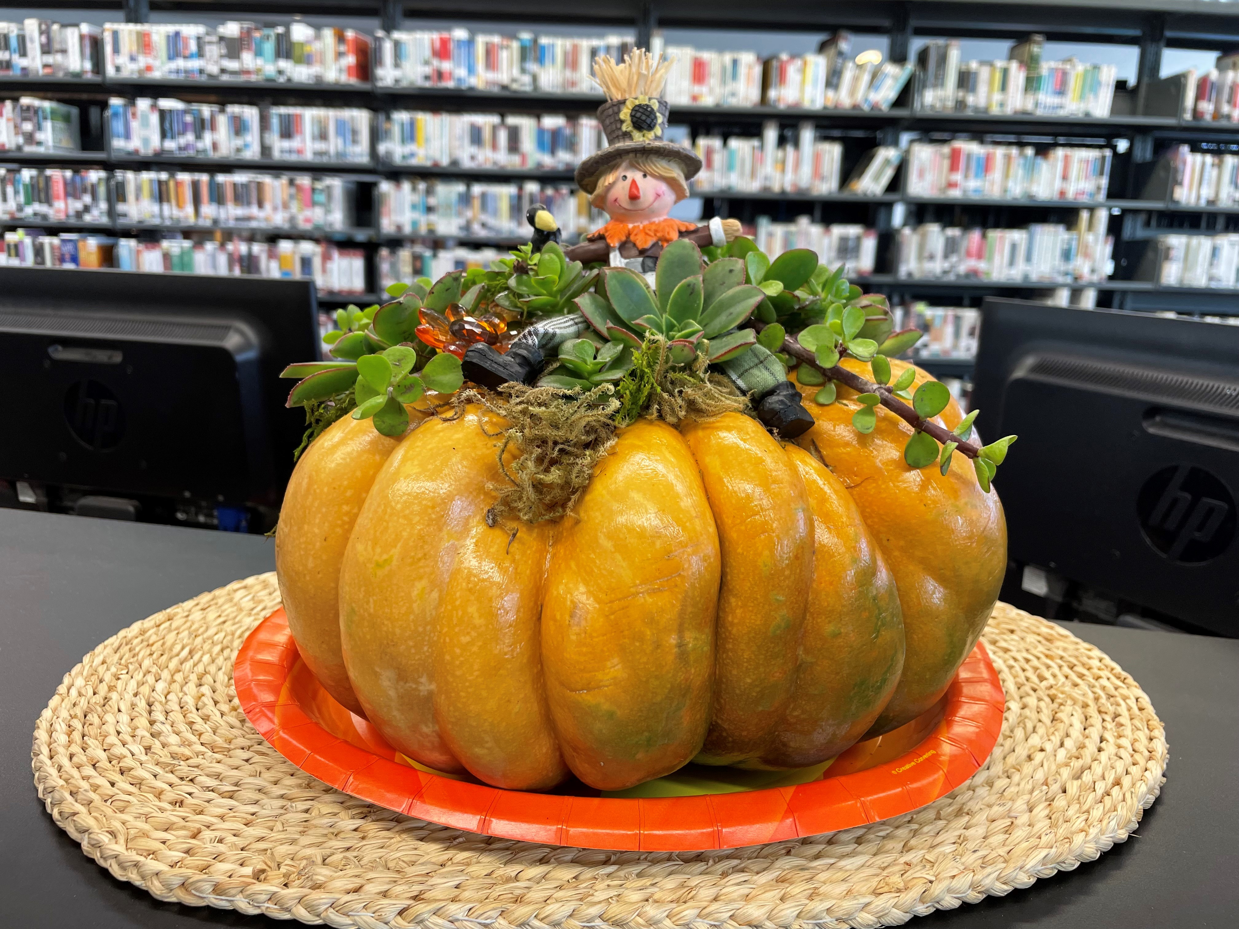 Pumpkin decorated with plants and a figurine