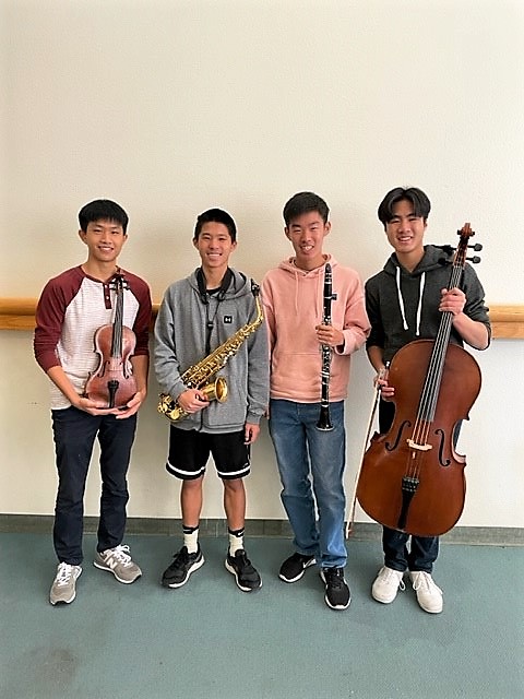 Photo of the four teen program presenters holding their musical instruments.