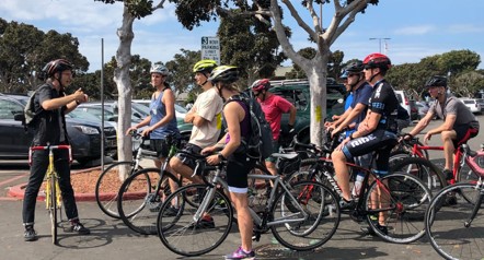 Photo of an instructor speaking to several people on bicycles