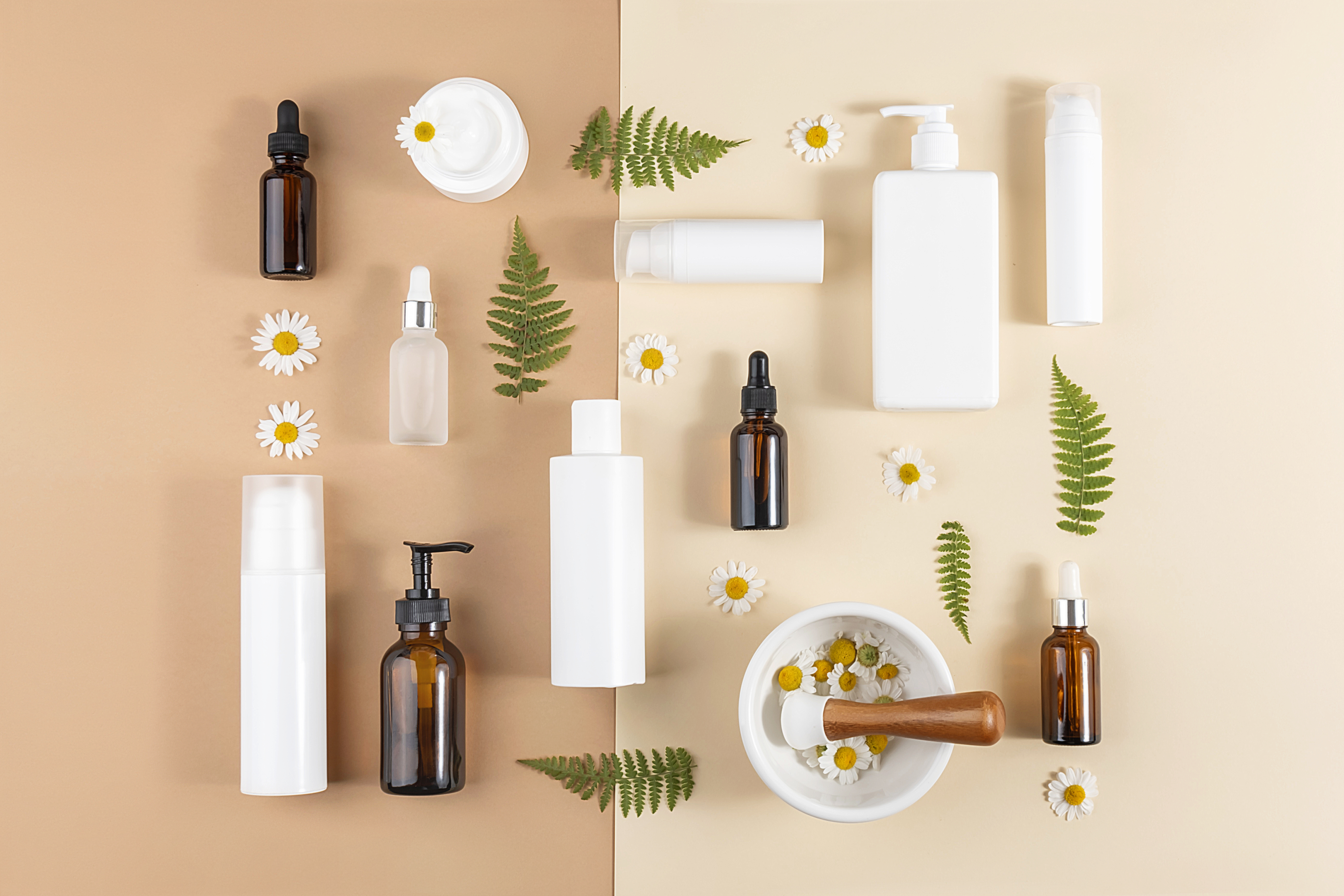 miscellaneous cosmetic bottles laid out on a beige background