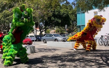 Two Lion dancers, green and yellow performing in 2019