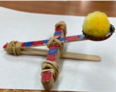 A mini catapult made out of craft sticks and rubber bands