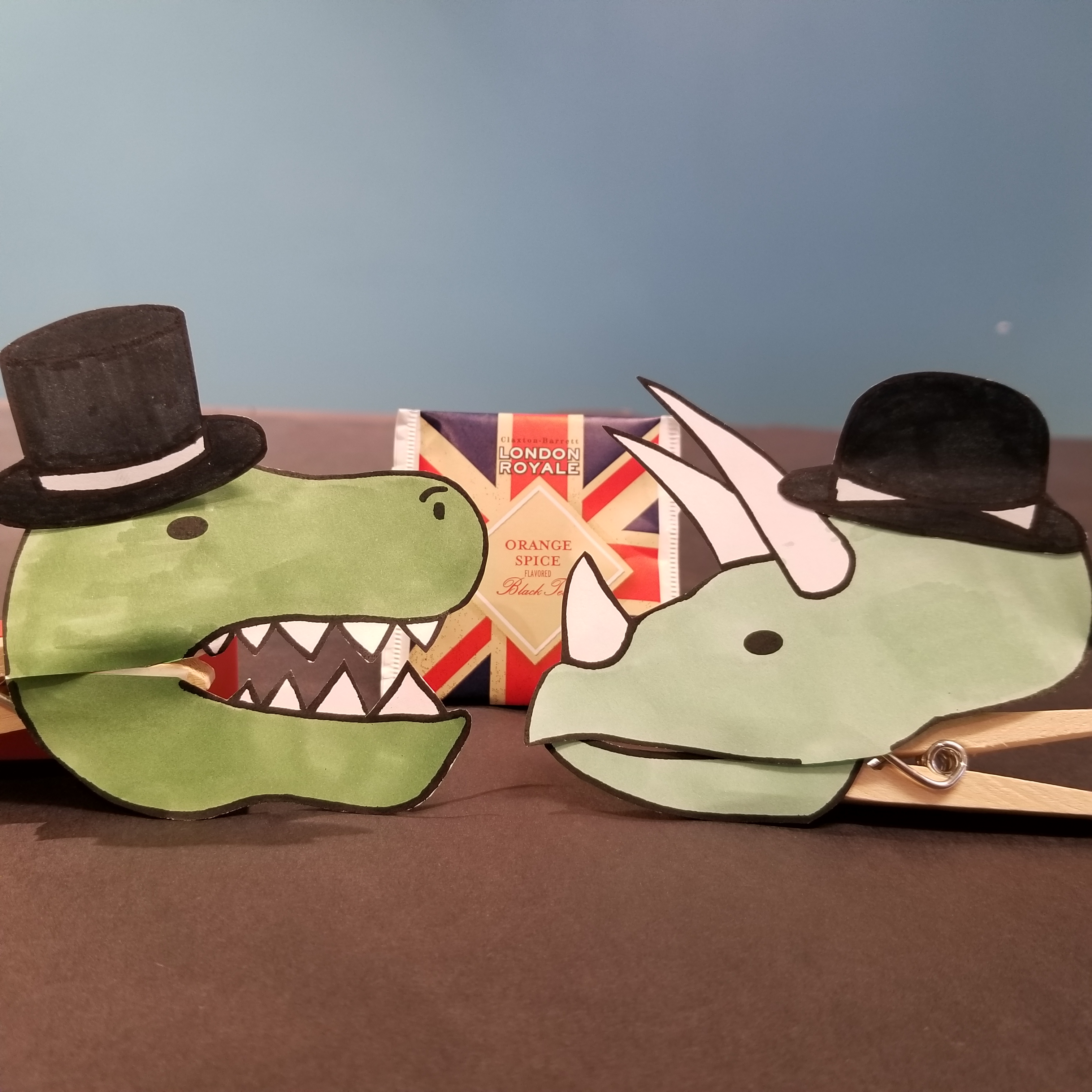 Dinosaurs in hats with tea