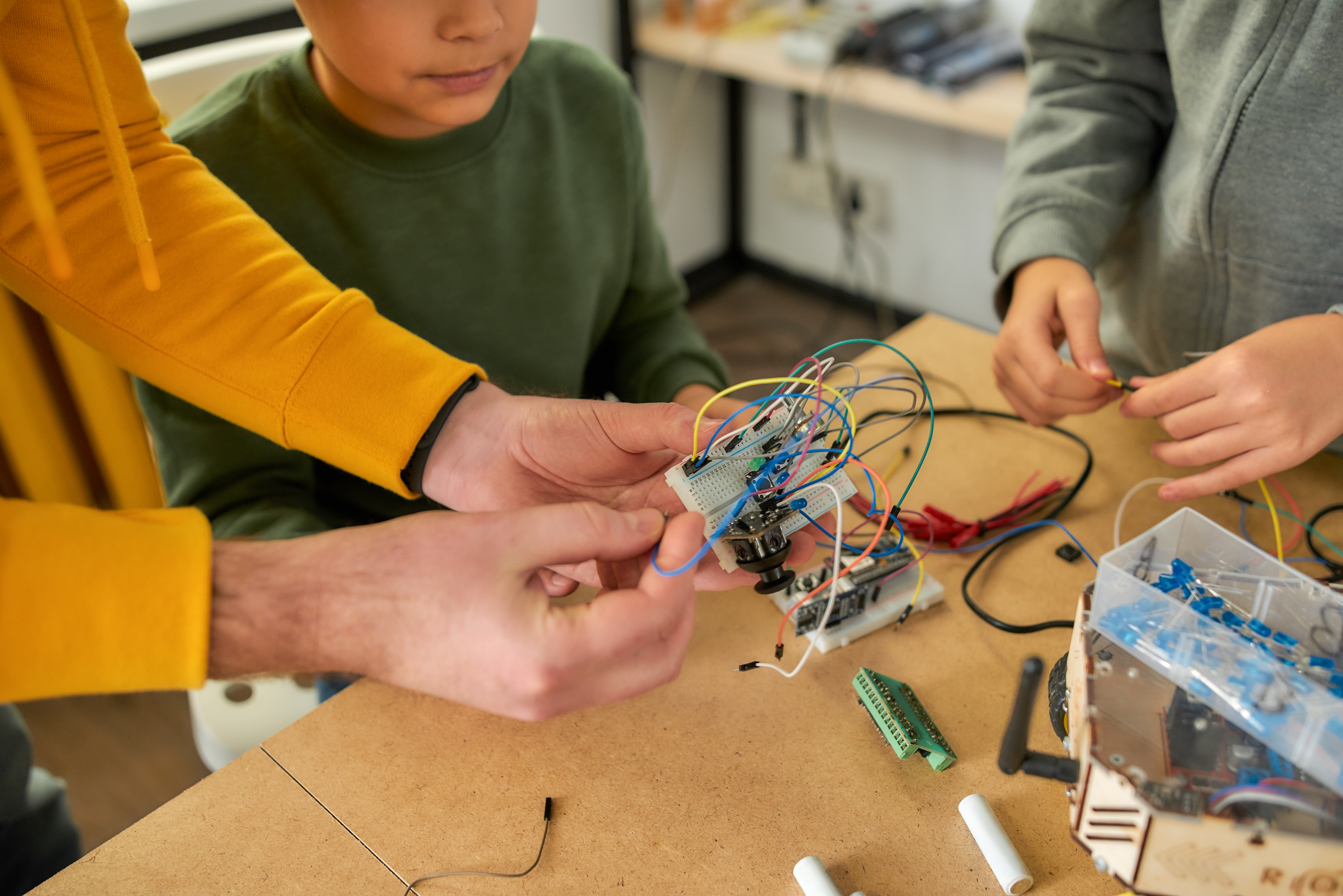 students and teacher working on breadboard with wires