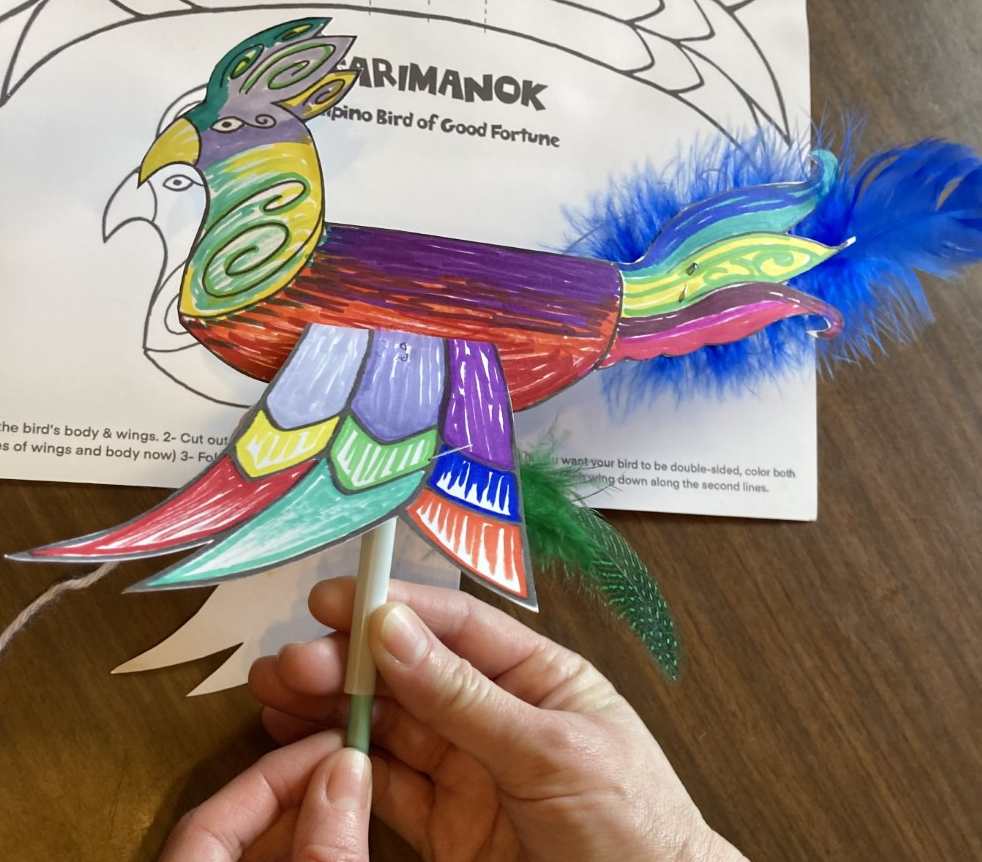 Brightly colored paper bird on a stick