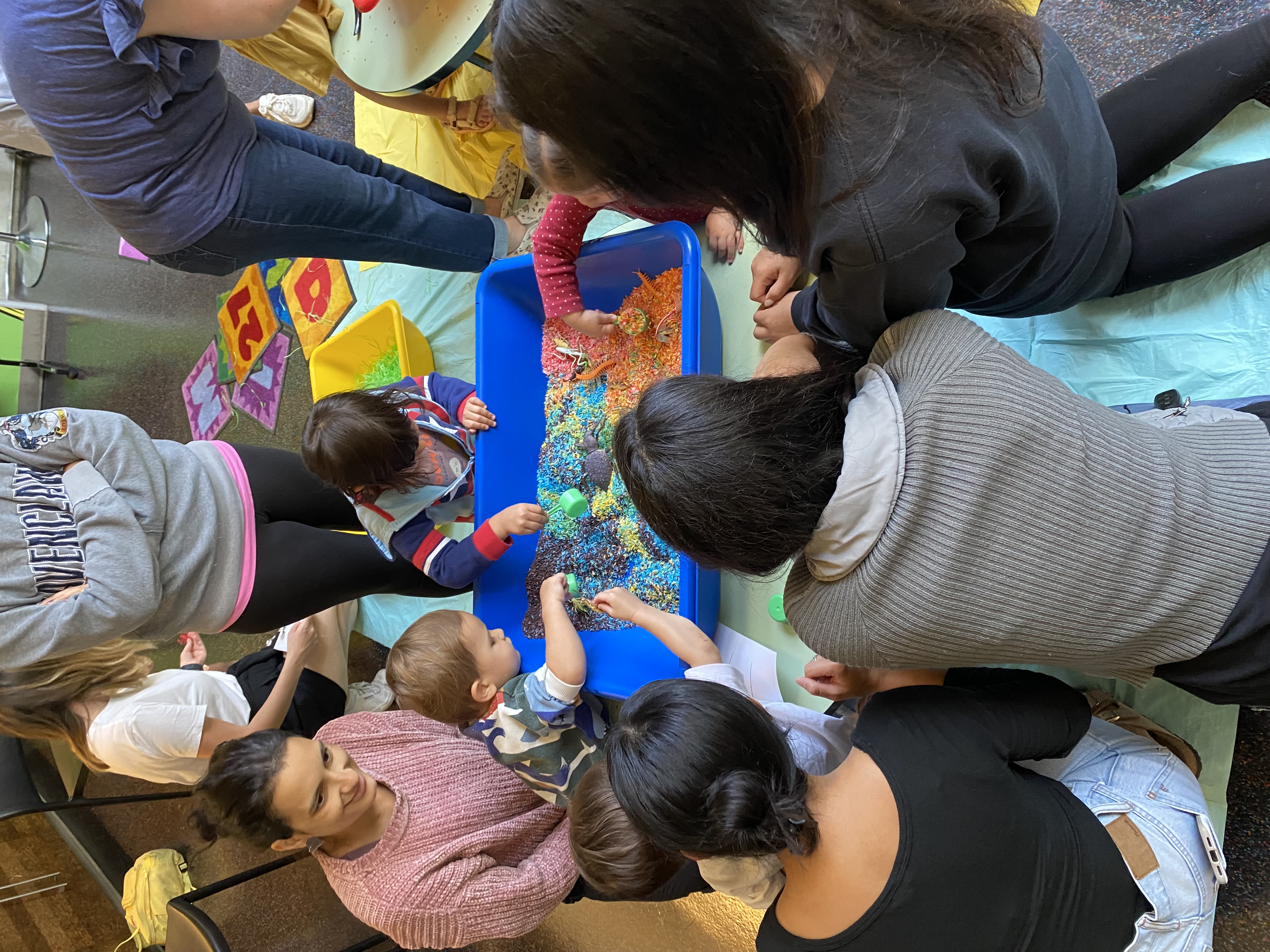 Children and caregivers playing with rainbow rice 