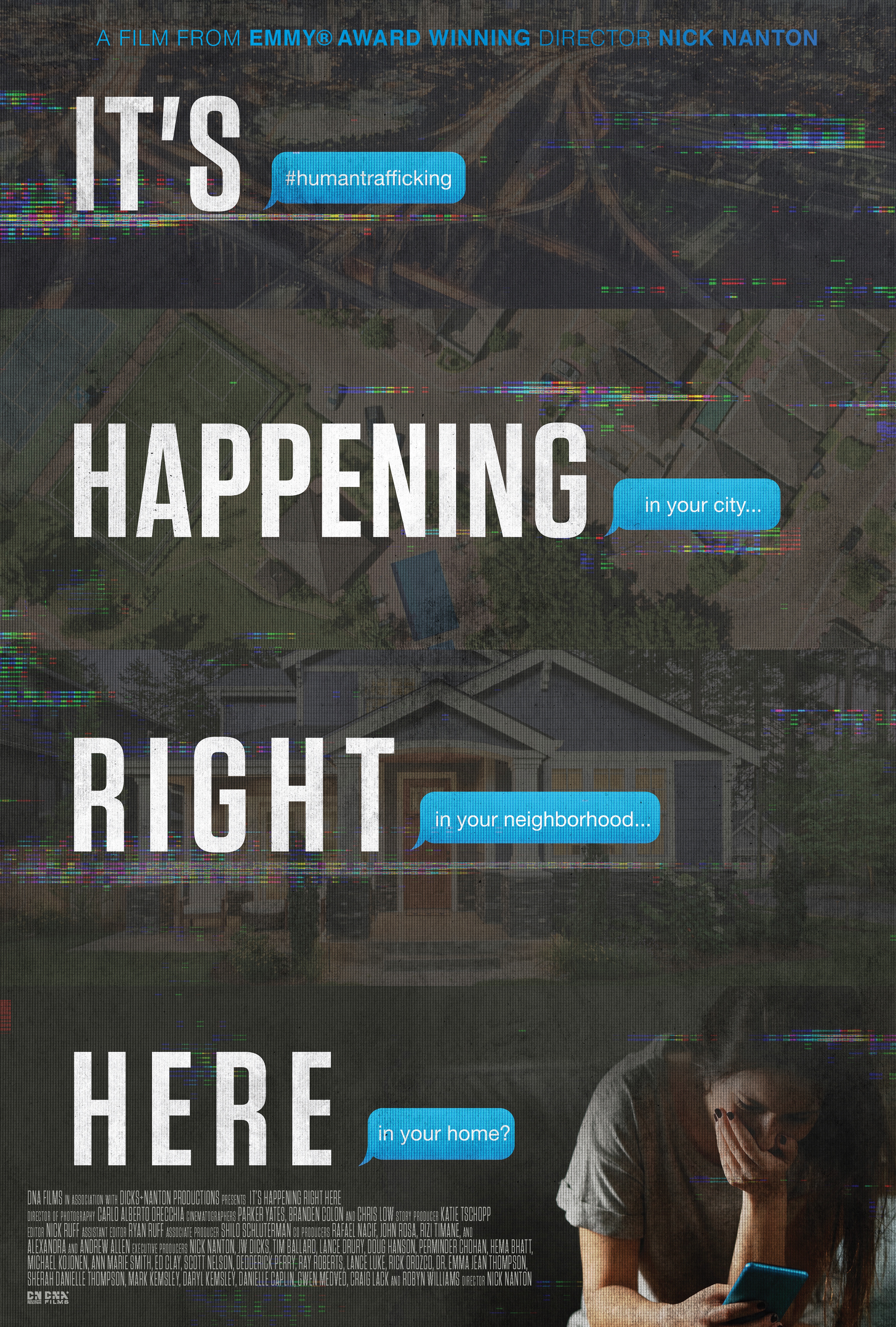 Film poster for It's Happening Right Here with white letters on a dark gray background featuring a woman hunched over a mobile phone.