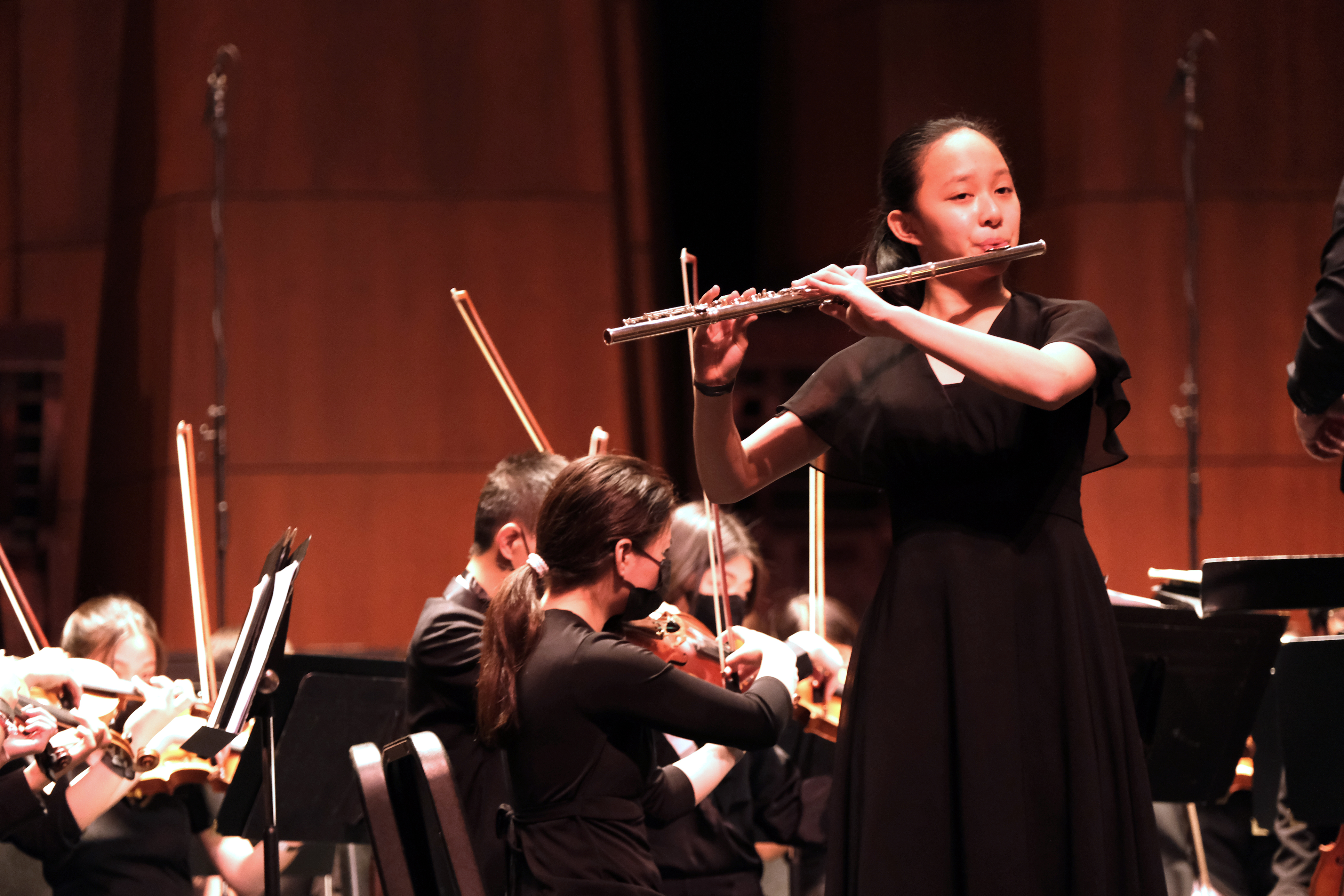 photo of previous SDYS competition winner performing on flute with an orchestra