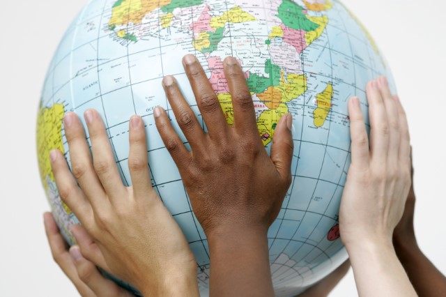 Photo of children's hands holding a globe.  