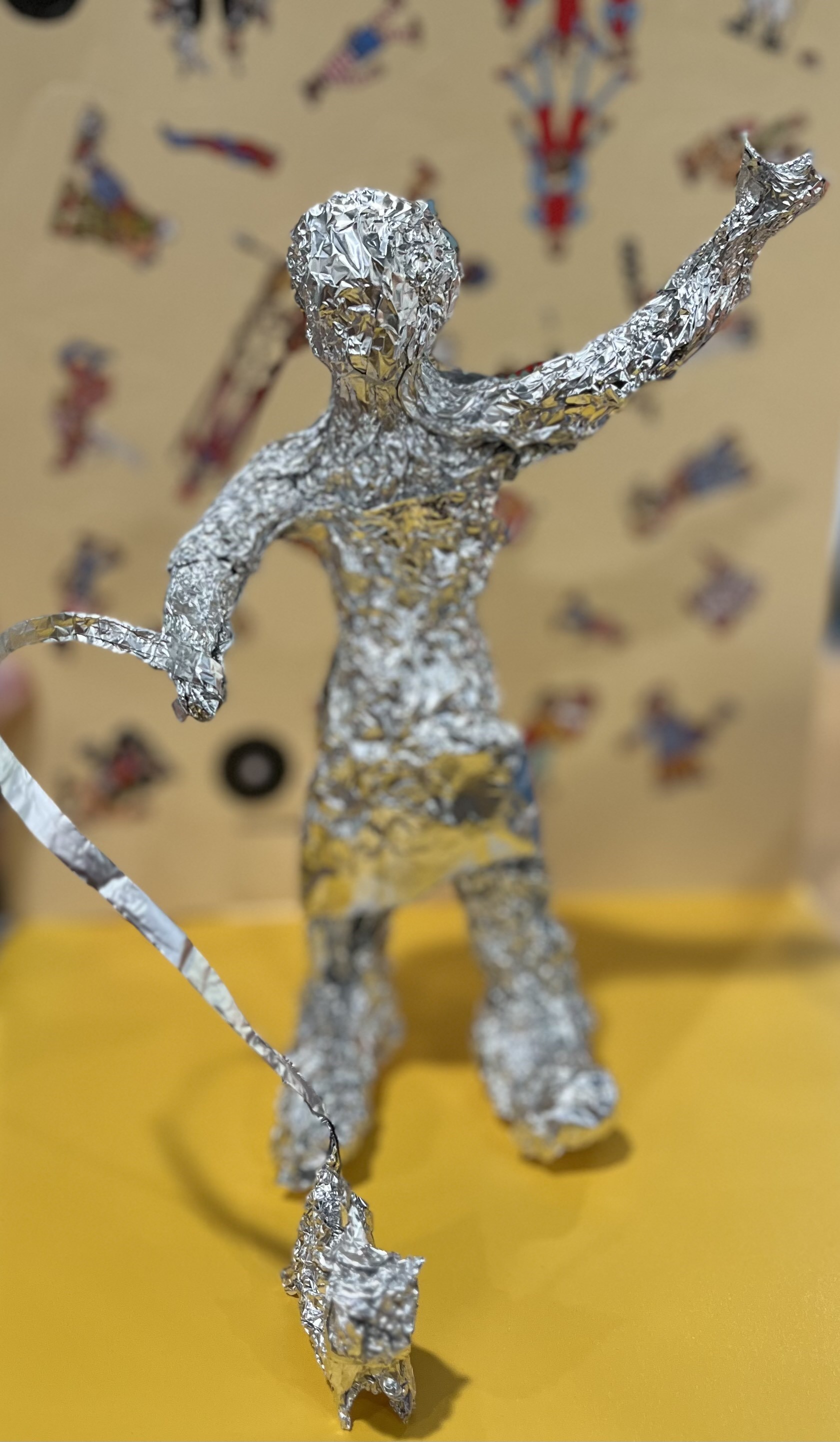 Tin foil sculpture of a woman walking a dog on a leash