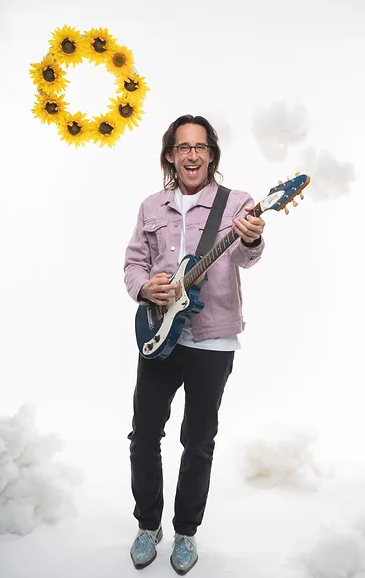 promo image of Ralph looking happy and holding a guitar while a yellow sun shines