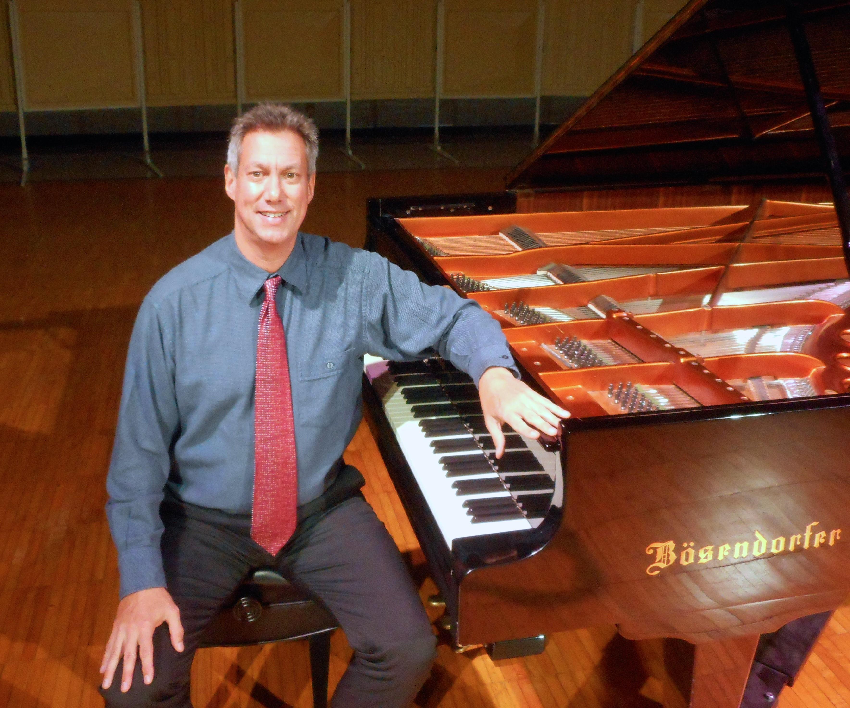 Pianist Mark Valenti seated at a piano